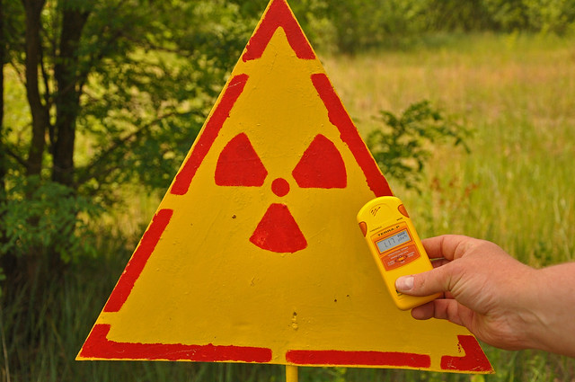 one of the guys on my tour using my dosimeter to test a homemade sign we saw across from the Chernobyl reactors