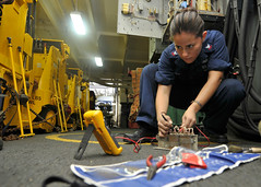 Houston native/Sailor uses a flow divider while fixing a forklift battery charging station in the hangar bay of USS Ronald Reagan