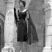 A fashion model in dress poses by column at Ancient Spanish Monastery: North Miami Beach, Florida