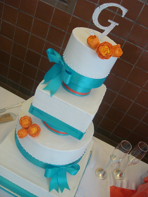 multishaped wedding cake in tangerine and malibu with orange ranunculus 