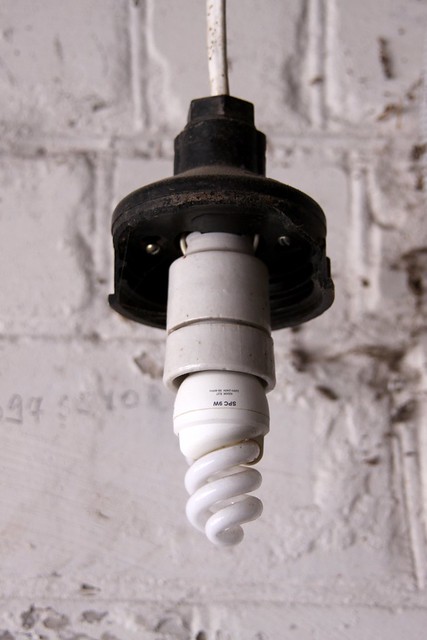  lámpara de ahorro de energía en un cartucho de edad contra una pared de ladrillo 