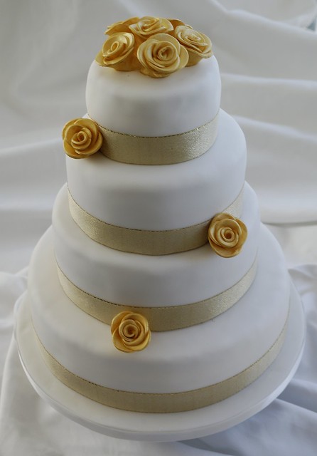 Gold Roses Wedding Cake Four tier white sponge cake with gold ribbon and 