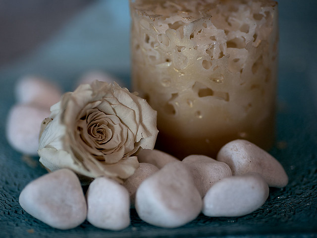 White rose, candle and stones