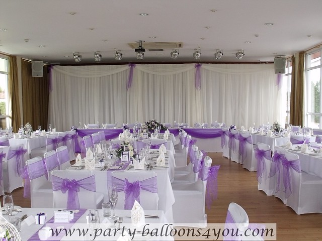 White chair cover with a purple organza sash bow