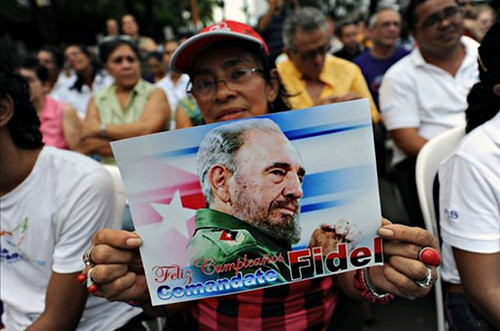 Cuban woman holds post of Comrade Fidel Castro during a 85th birthday celebration for the revolutionary leader. Fidel was president and head of the Communist Party of Cuba for decades. by Pan-African News Wire File Photos
