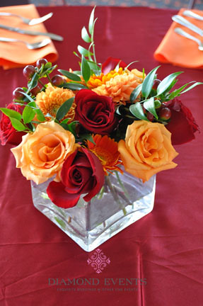 The tables were set with a maroon satin overlay orange napkins and 