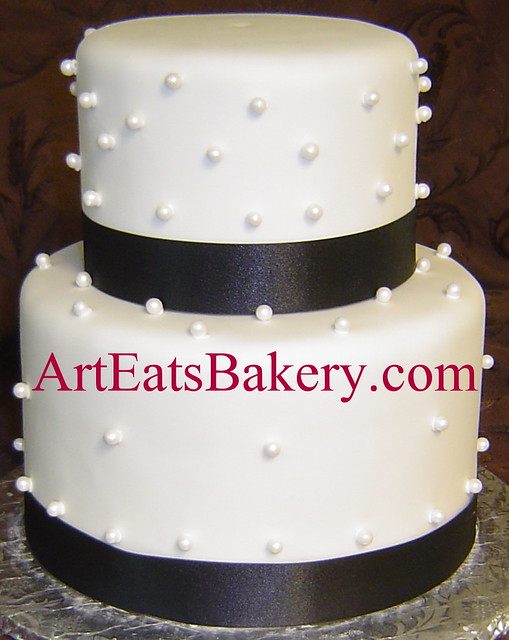 Two tier whtie fondant wedding cake with sugar pearls and black ribbons