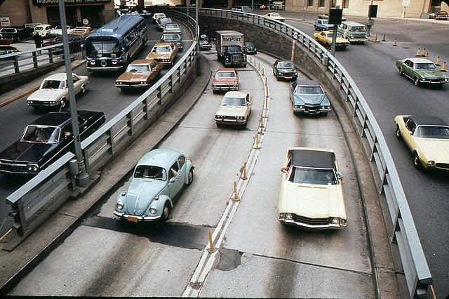 1960s and 1970s car heaven. I spy a 1960s Chevy Impala, a 1971 Camaro, a Chevy Nova, a Datsun (?), Cadillac, a GMC Flxible bus, a 1960s Dodge Van and lots of VW Beetles.  What do U see? Brooklyn Battery Tunnel traffic. New York. May 1973