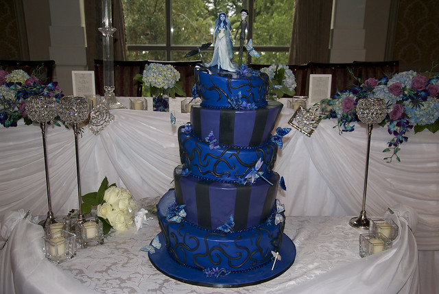 A 5 tier topsy turvy wedding cake in royal blue and dark purple with a 