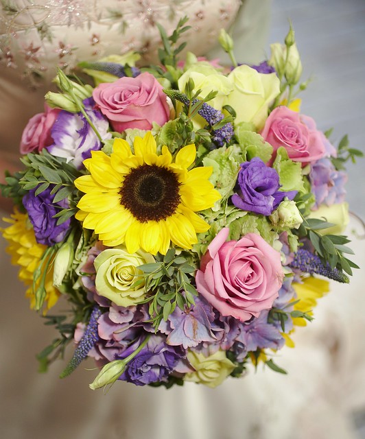 This is a gorgeous bridal bouquet made with sunflowers roses and freesia