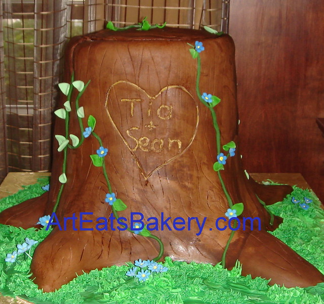 3D tree stump wedding cake with green vines and blue flowers