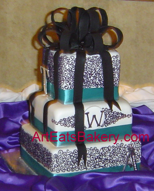 Three tier square white fondant wedding cake with purple curlicue teal 