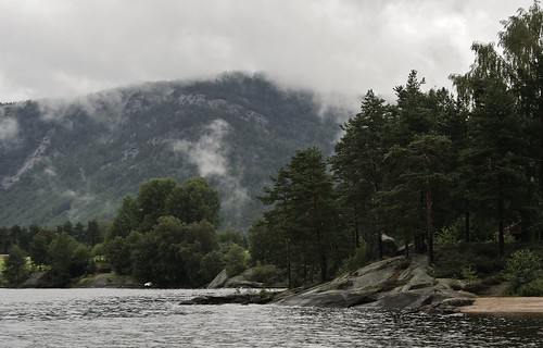 Norwegian lake,  with fog coming down the hillsides.