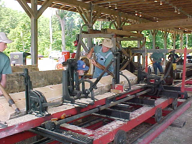 Volunteers run knotty pine through the historic lumber mill.