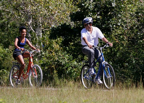 President Barack Obama, and daughter Malia, ride bicycles