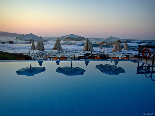 sunset sea pool reflections hotel waves parasols corinnamare