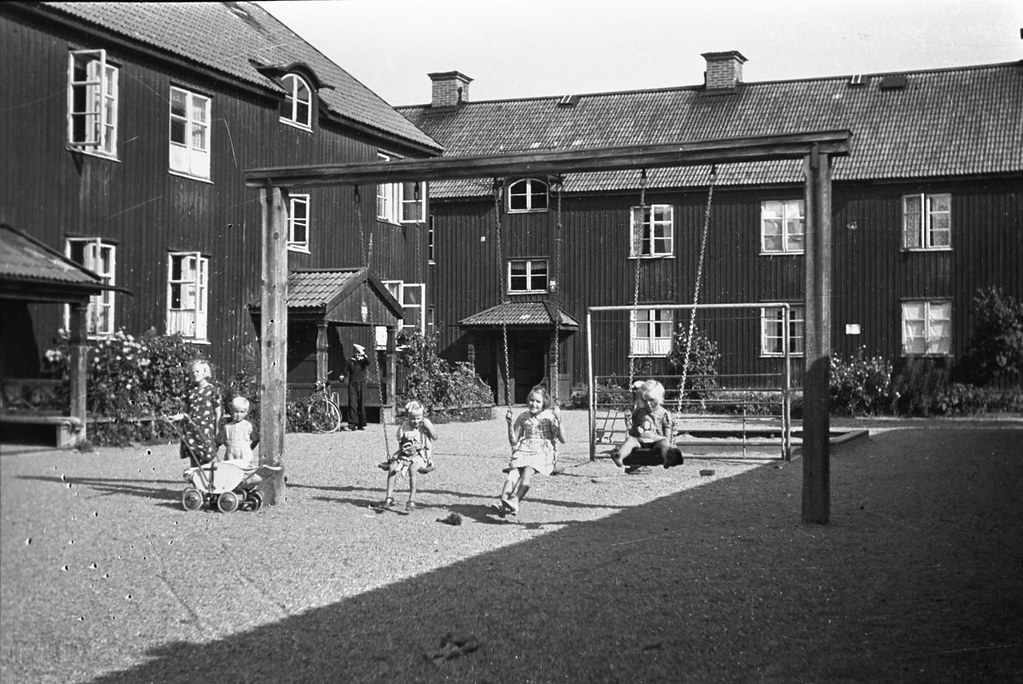 Children on a swing in front of house in Stockholm 1942