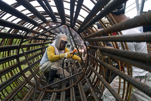 Man working inside a large reinforced steel tube, Phillippines. Photo credit: Flickr @Nonie Reyes, World Bank Photo Collection