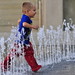 Boy running through fountain (125mm / 187mm; 1/200; f/2.8)
