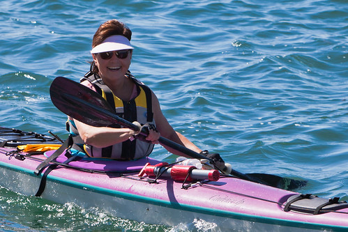 Closeup crop. A smile goes a long way.  This female kayaker reacts positively to having her photo taken - Morro Bay visitors must be the most friendly people in the world.   This wind was picking up making water sports interesting today.