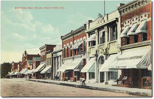 people usa signs man color men history boys kids buildings advertising children awning furniture indiana streetscene bicycles transportation shops pedestrians storefronts crownpoint banks businesses lakecounty hoosierrecollections